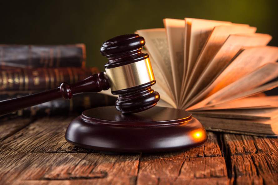 Hammer and Gavel on a Wood Surface Next to Law Books