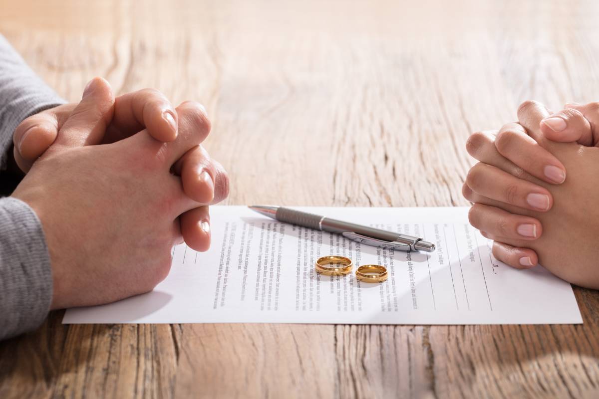 Two people's hands on either sides of a divorce settlement near Lexington, Kentucky (KY)
